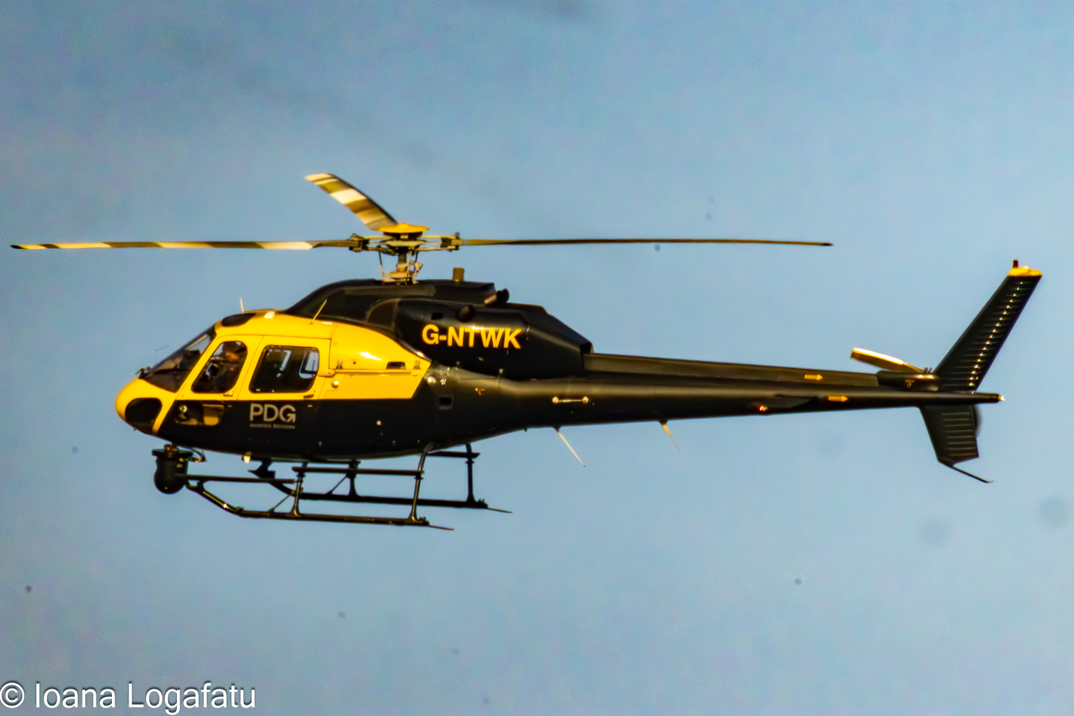 Helicopter soaring above clear blue skies